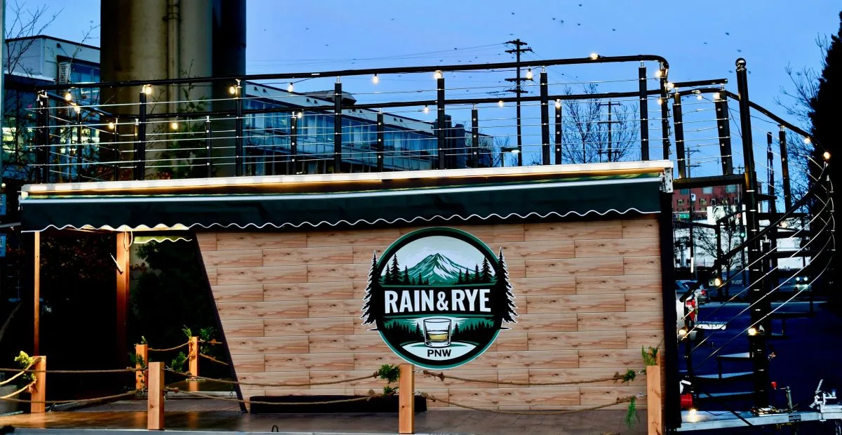 The mobile bar with its awning out and logo visible at dusk