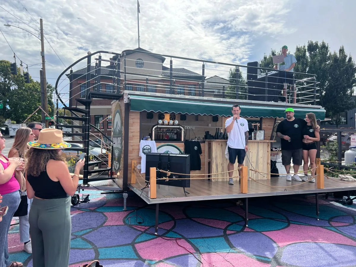 Guests gathered around the mobile bar at an outdoor daytime event